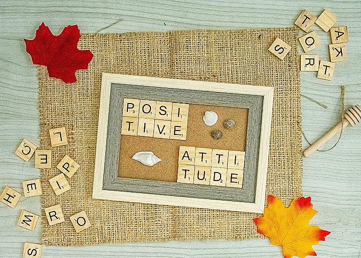 a picture frame surrounded by scrabbles and autumn leaves