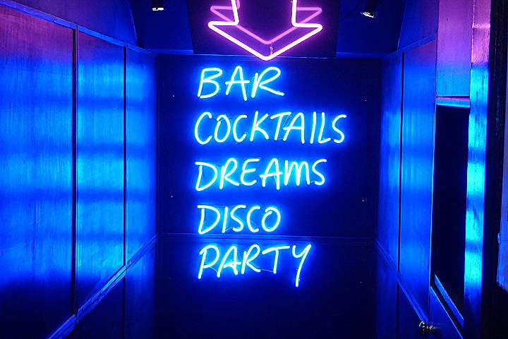 neon sign reading bar cocktails dreams disco party