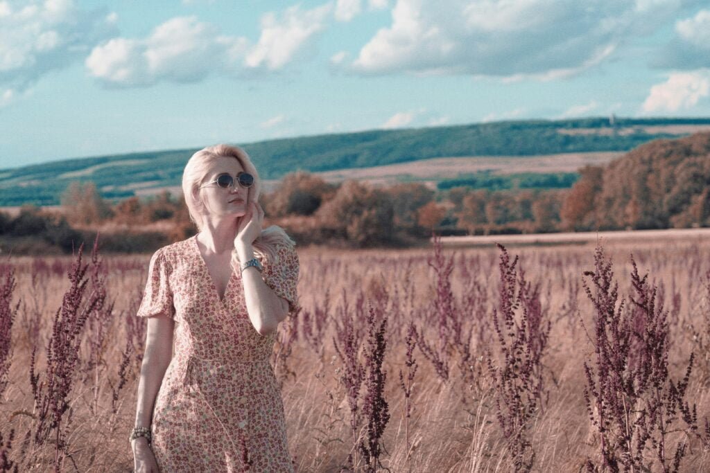 a woman standing in a field of tall grass